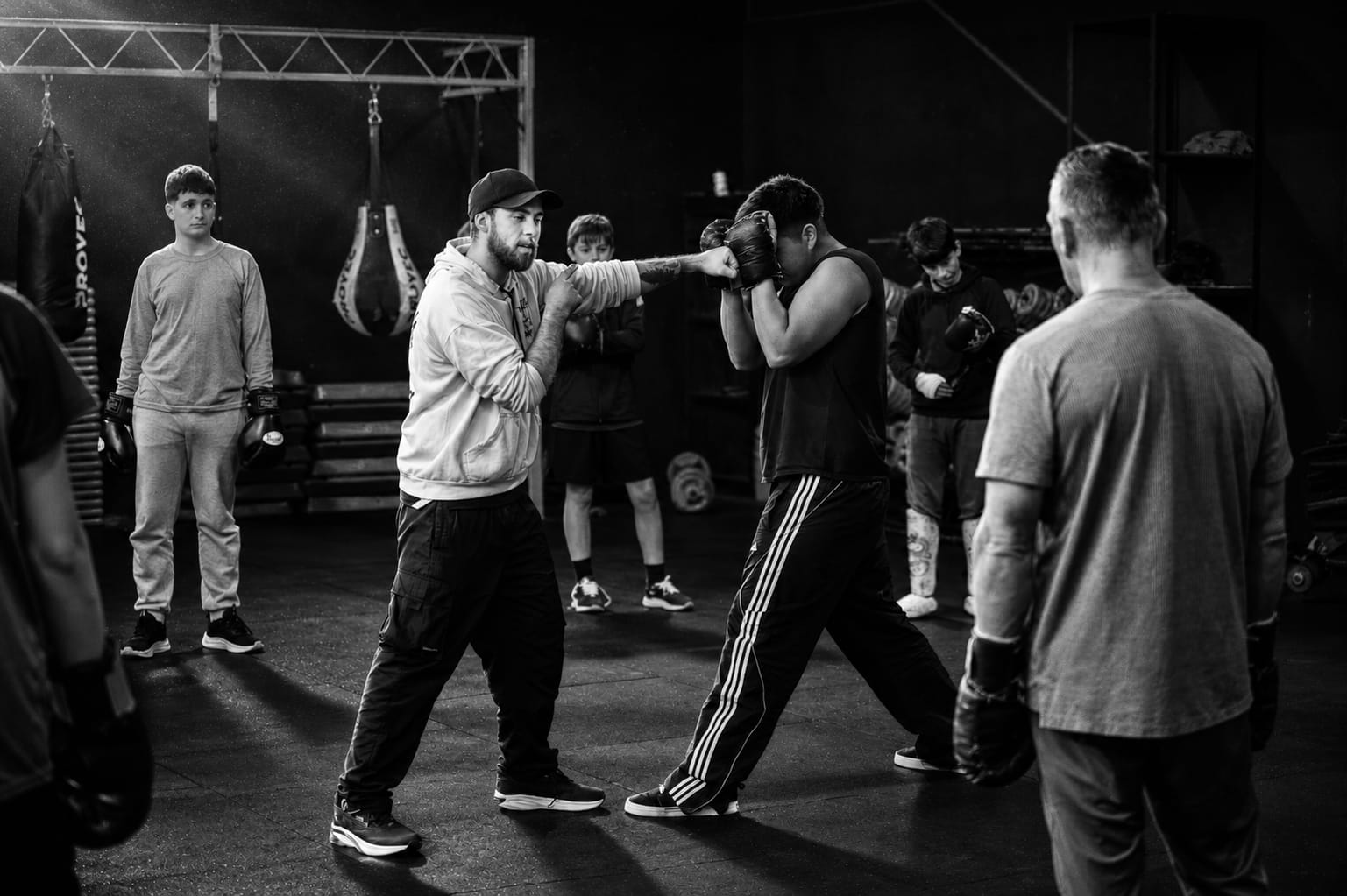 Clase de boxeo recreativo: el profe practica golpes con un alumno